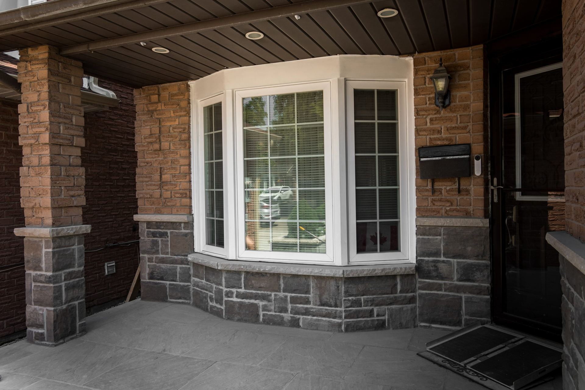 Concrete porch landing beside stone-clad walls